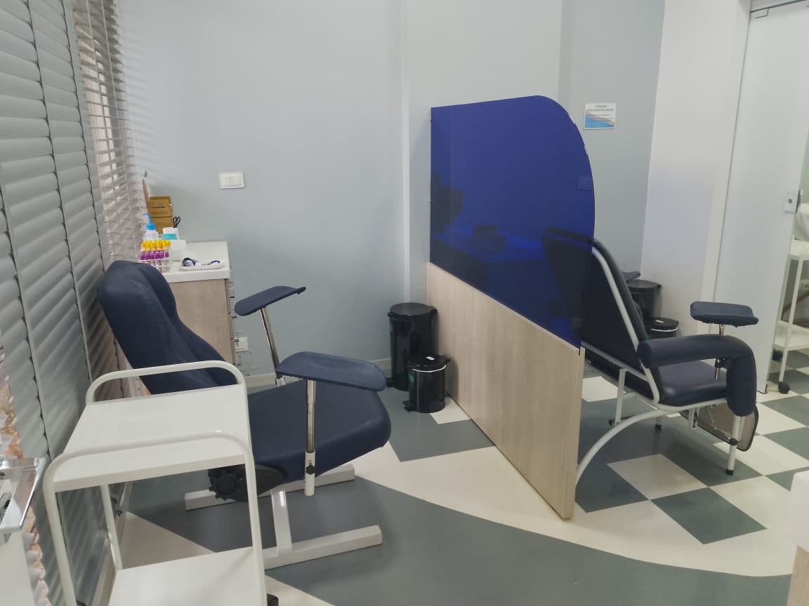 Sala de coleta com duas cadeiras e divisória
